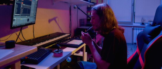 Male composer light cigarette during make music