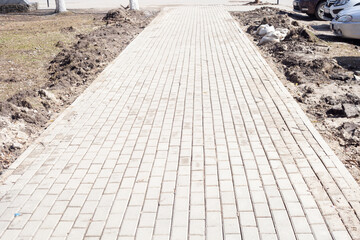 around the pavement path with tiled slabs a lot of construction debris