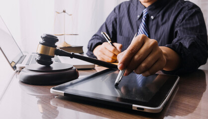 Male lawyer working with contract papers and wooden gavel on tabel in courtroom. justice and law ,attorney, court judge, concept.