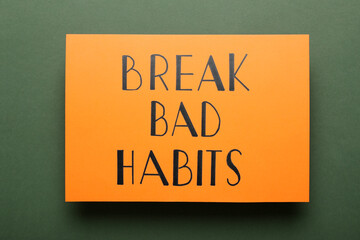 Orange sheet of paper with phrase Break Bad Habits on green background, top view