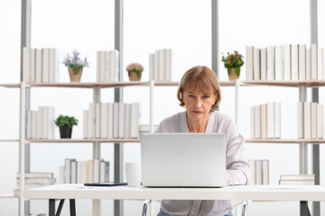 senior woman using laptop computer and serious at work