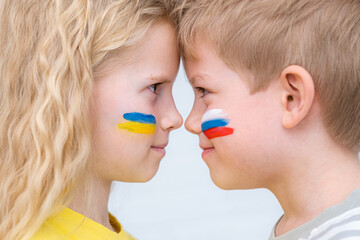 Portrait boy and girl looking each other with flags Ukraine Russia painted on face. Concept of truce negotiation reconciliation peace good friendship, conflict and stop war