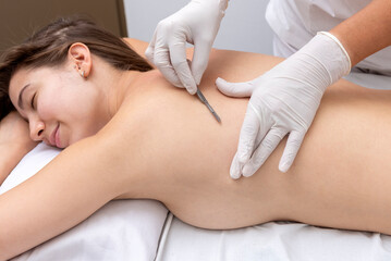 young woman in a beauty and spa center performing a beauty treatment for body and skin care with a dermaplaning technique