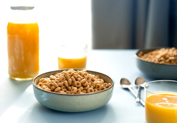 Breakfast concept with cold cereals and orange juice on blue background