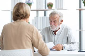 senior businessman or employer asking and talking about works to coworker