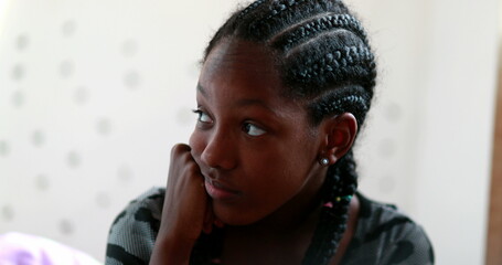 Pensive Black teen girl child thinking. Thoughtful sad depressed teenager adolescent girl