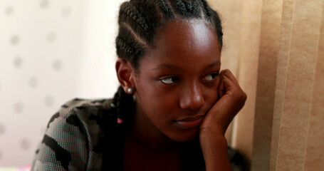 Pensive Black teen girl child thinking. Thoughtful sad depressed teenager adolescent girl