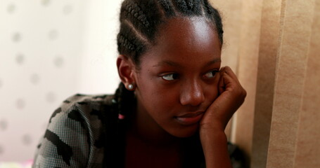 Pensive Black teen girl child thinking. Thoughtful sad depressed teenager adolescent girl