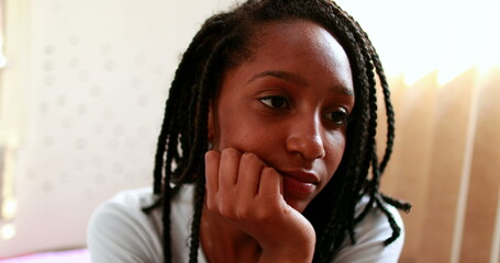 Fototapeta na wymiar Pensive black African girl thinking in adolescent room. Thoughtful mixed race teenager