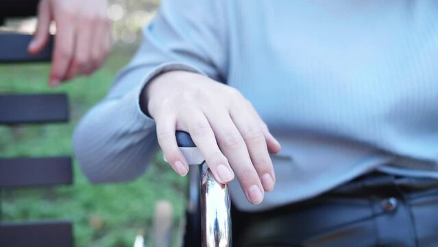 affection, love-hand of man caresses that of his girlfriend with paraplegia