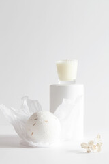 Obraz na płótnie Canvas bath bomb and candle on podium on white background. Still life for wall decoration in resort spa or salon. Spa, relax, wellness concept. 