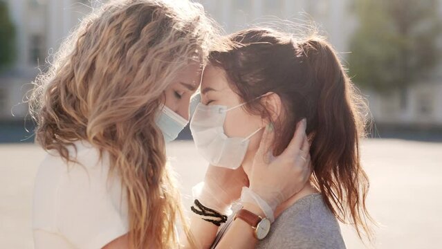 Young womans take off medical mask and kiss. Pandemic is over. Finally end of quarantine. Pretty couple date after long self isolation. Health care and medical concept. Happy people.