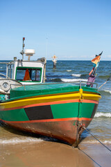 Fishing boat by the sandy beach on the Baltic Sea on a sunny day, Sopot, Poland.
