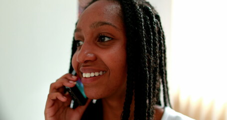 Black girl speaking on phone. African teenager speaks on smartphone