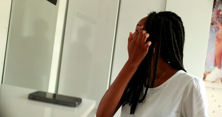 African teenager girl inspecting herself in front of mirror