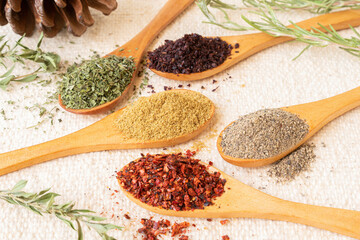 Various spices on wooden spoons. Aromatic food ingredients.