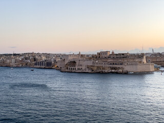 Fototapeta na wymiar Alongside Kalkara Creek and poking into the Grand Harbour is the fortified city Birgu (Vittoriosa), Malta. At its end is Fort St Angelo.