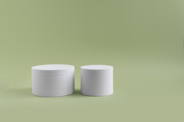 White geometric shapes on a green dull background with space for text and design. Minimalistic composition of white geometric shapes, cube. Abstract composition for any text. Blog on any topic. 