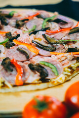 pizza with black mushrooms, ham and tomatoes 