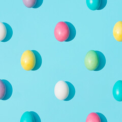 Trendy pattern made of colorful Easter eggs on bright blue background. Minimal Easter concept. Creative food layout.