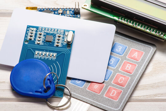 Door access control keypad, magnetic key breadboard and display on the white background.