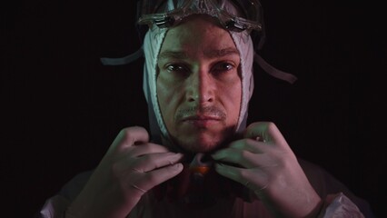Man in protective costume suit, gas protect medical antibacterial antiviral spray paint mask. Doctor health worker in respirator. Concept health virus coronavirus epidemic. Radiation Nuclear war.
