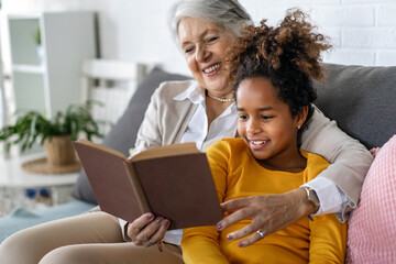 Grandmother studying with multiethnic grandchildren for school