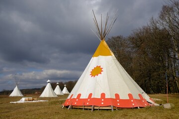 Large white Indian tents stand in the field