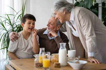 Happy mixed race family. Smiling grandparents having fun with boy grandchild together at home.