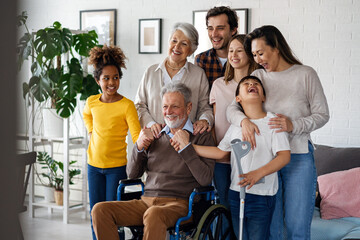 Multi generation, multiethnic family at home together, grandfather with disability - obrazy, fototapety, plakaty