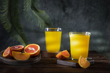 Glass of fresh orange juice with fresh fruit on a wooden table Still life with fresh orange juice...