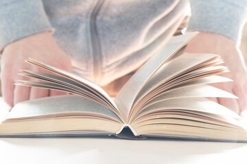 Paper books.A person reads paper books on a table.
