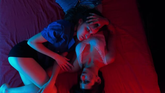 young beautiful lesbians lying on the bed fondle each other- tenderness, love