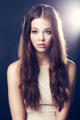 Fototapeta premium Beauty so great you need to shine a light on it. A gorgeous young woman backlit with bright lights while isolated on black.