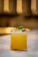 Yellow cocktail on a modern bar. Yellow bokeh background 