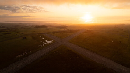 Orange sunrise over abandoned airfield