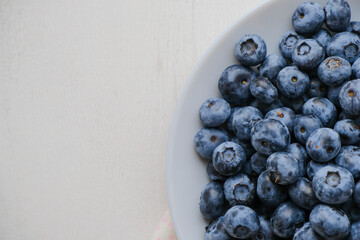Fresh raw organic blueberries in a plate on a natural linen napkin on the table. Healthy nutrition. Minimalistic simple natural light flat lay template. Superfood. Organic eco health care. Vitamins.