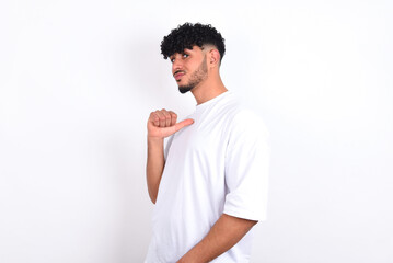 Closeup of cheerful young arab man with curly hair wearing white t-shirt over white background ...