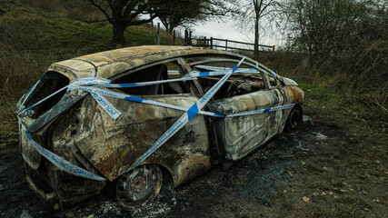 Burnt out car wrapped in police tape