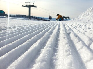 Prepared ski trail. Panoramic point of view the skier's feet on the descent start from a straight line, rows of freshly prepared well-groomed ski slopes