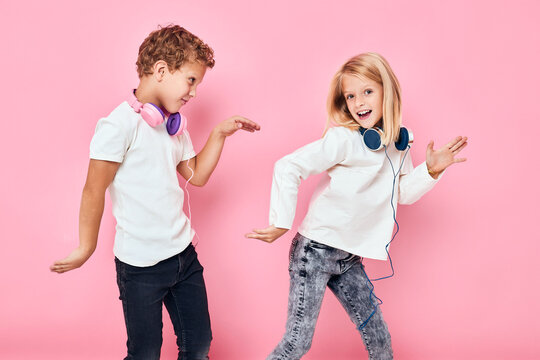 Stylish little boy and cute girl stand next to in headphones studio childhood