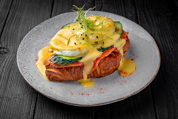 Croissant sandwich with salted salmon, cucumber, egg and cheese. Healthy, tasty, nourishing snack. Take away food