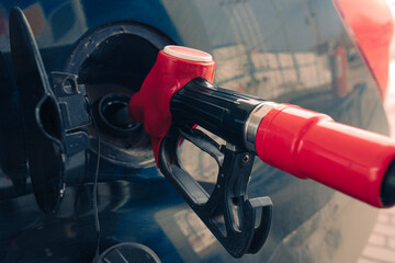 Pumping gasoline fuel nozzle to refuel. Vehicle fueling facility at petrol station. Car at gas...