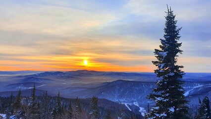 Sunrise in the mountains in winter. Majestic sunset in a winter mountain landscape. Dramatic sky.