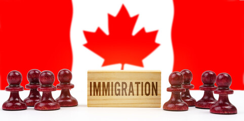 Against the background of the flag of Canada, pawns and a sign with the inscription - immigration - obrazy, fototapety, plakaty