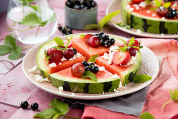 Fresh summer salad with berries and fruits on watermelon with feta cheese