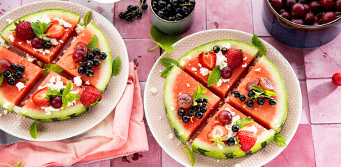 Fresh summer salad with berries and fruits on watermelon with feta cheese