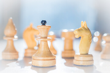 Chess pieces bathed in sunlight. The image is in a high key. The chess queen leads the warriors. Abstraction of leadership and development strategy. Business.