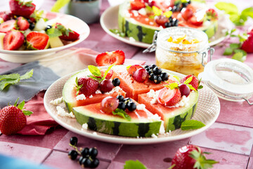 Fresh summer salad with berries and fruits on watermelon with feta cheese