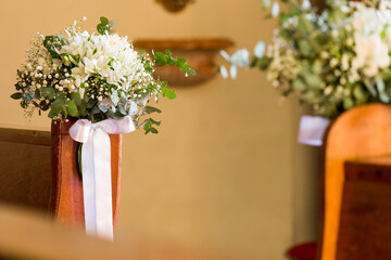 wedding decoration on the church benches